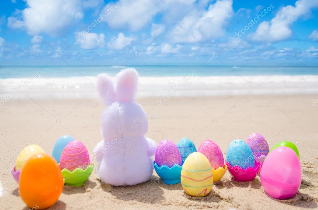 Easter bunny and color eggs on the beach — Stock Photo 43569597