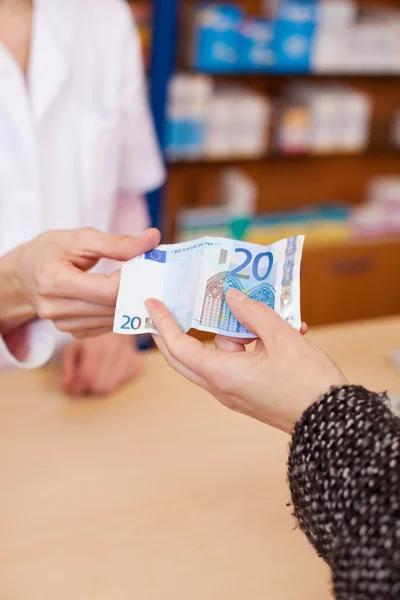 Customer Hand Paying Money To Pharmacist