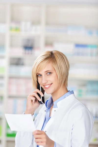 Smiling pharmacist using telephone