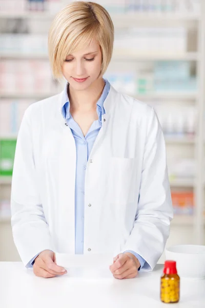 Pharmacist reading prescription paper
