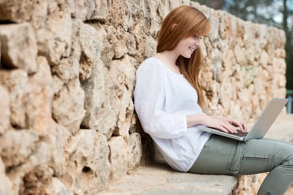 Woman relaxing typing on her laptop