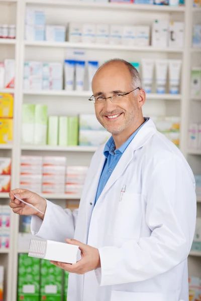 Pharmacist Holding Medicine And Prescription Paper In Pharmacy