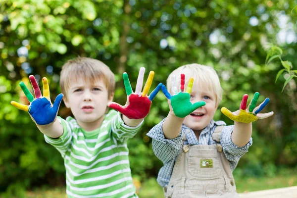 Two boys having fun and showing colorful hands — Stock Photo #26160779