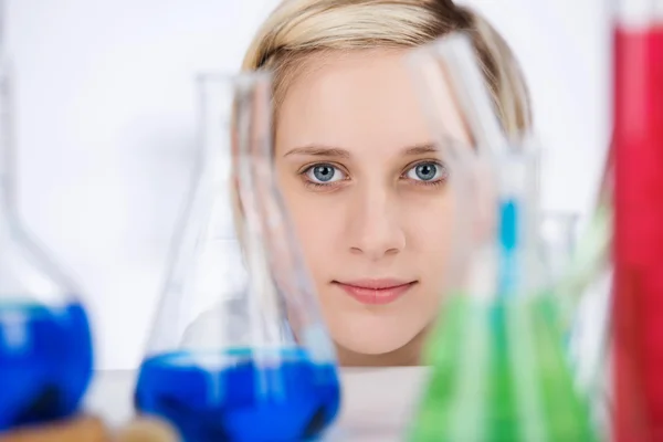 Female Scientist With Chemicals On Laboratory Desk