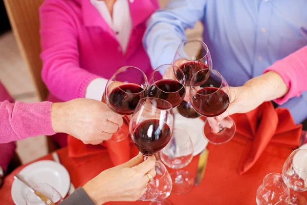 Customers Toasting Wine Glasses At Restaurant Table