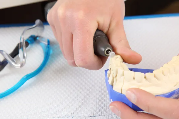Dental surgeon molding prosthetic teeth