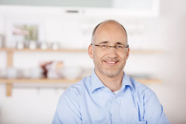 Smiling bald man in kitchen