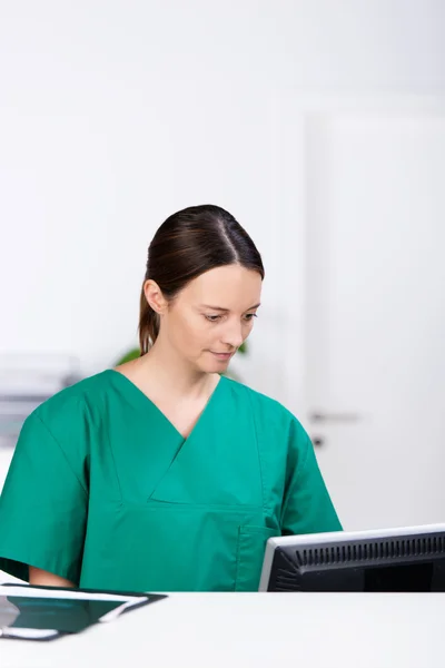 Female Surgeon Looking At Computer At Desk