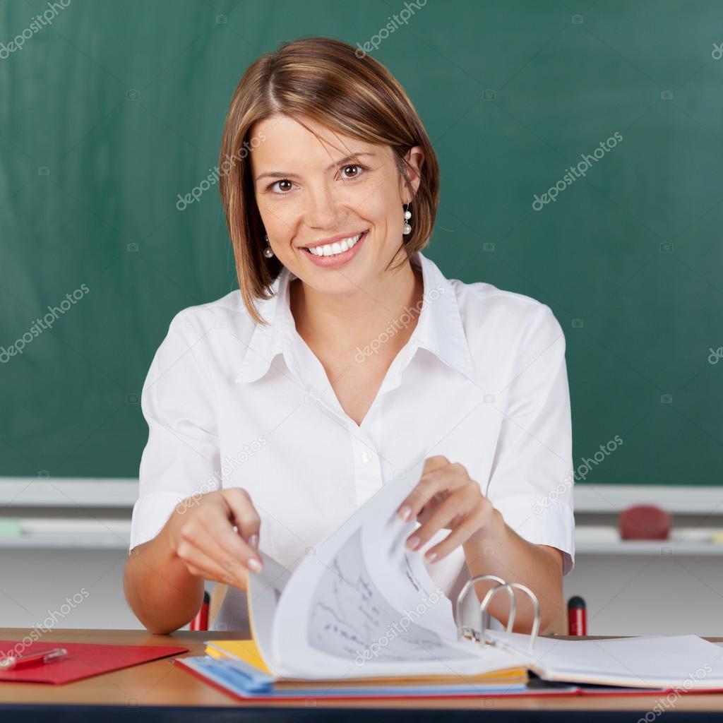 Smiling teacher checking her notes for class — Stock Photo © racorn