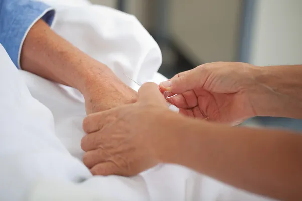 Doctor Adjusting Drip On Patients Hand