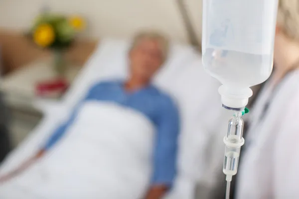 Infusion Bottle With Patient And Doctor In Hospital