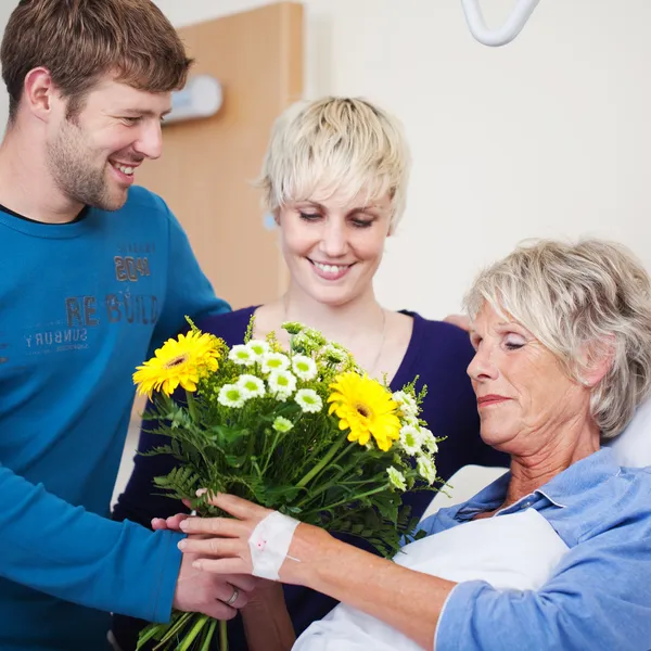 Children Giving Flower Bouquet To Mother In Hospital