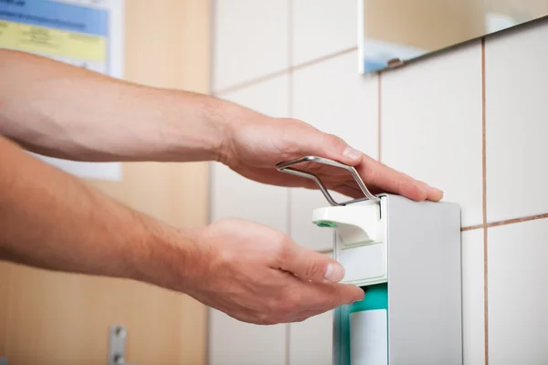 Doctors Hands Using Sanitizer Dispenser In Washroom