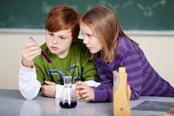 Two young children studying chemistry