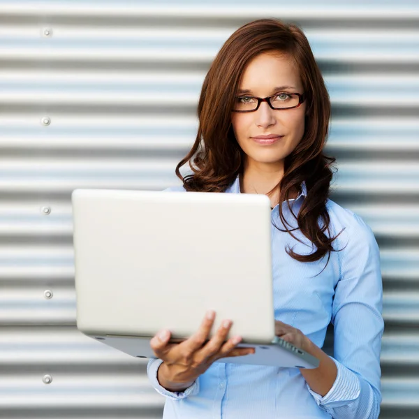 Woman posing while holding the laptop