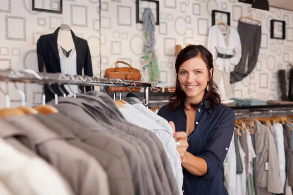 Smiling Woman Choosing Shirt In Clothing Store