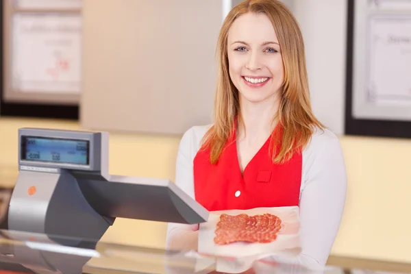 Friendly female worker at the cash counter