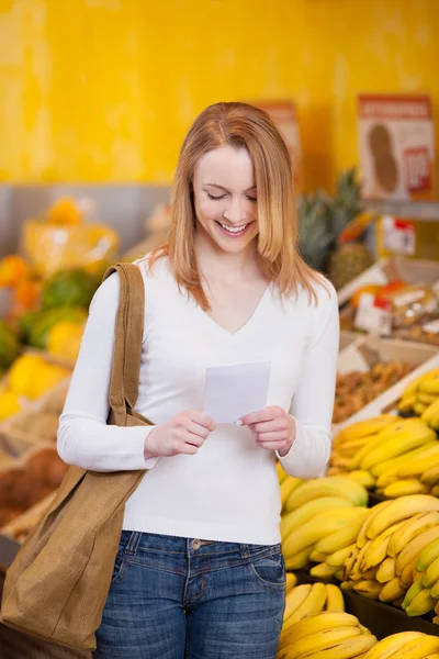 Woman Reading Checklist In Grocery Store