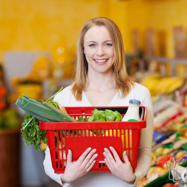 Beautiful Woman Carrying Shopping Basket In Grocery Store
