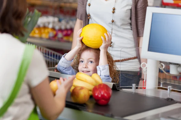 Girl Giving Muskmelon To Cashier For Billing At Supermarket