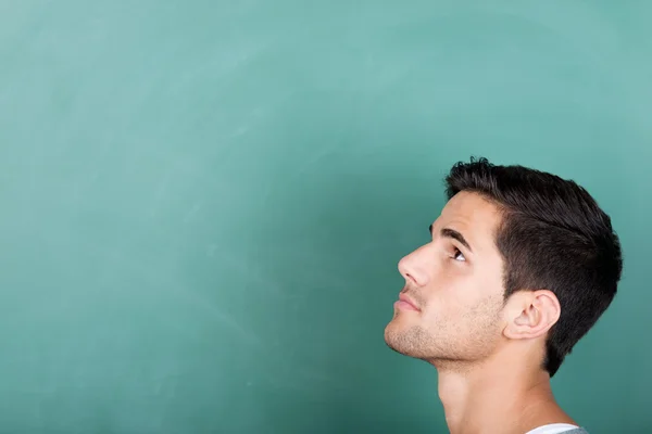 Thoughtful student in front of a blackboard — Stock Photo #27010471