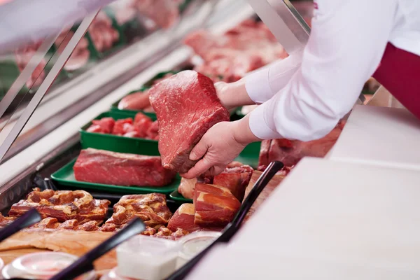 Saleswoman offering fresh meat in supermarket