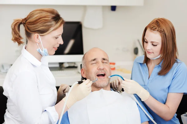 Dentists Examining Patients Mouth With Tools