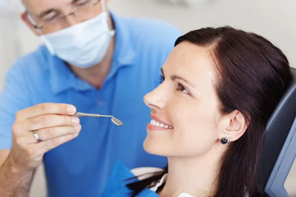 Examining Female Patient's Mouth In Clinic