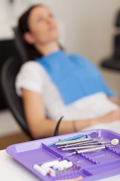 Tool Tray With Customer Sitting On Chair At Dental Clinic