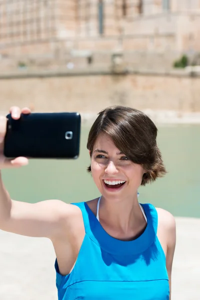 Laughing woman photographing herself — Stock Photo #27775451