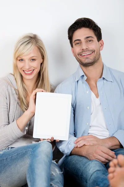 Couple With Digital Tablet Sitting Against Wall