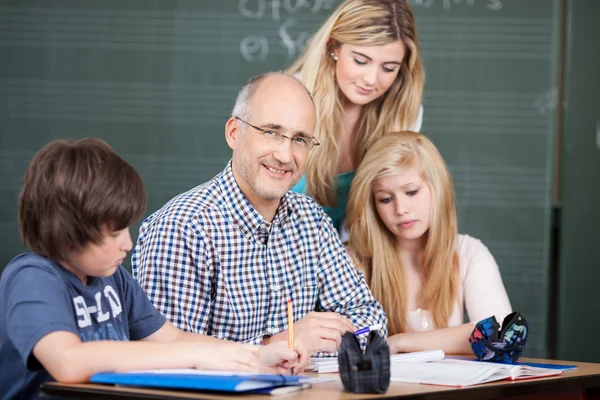 Male teacher surrounded by his pupils