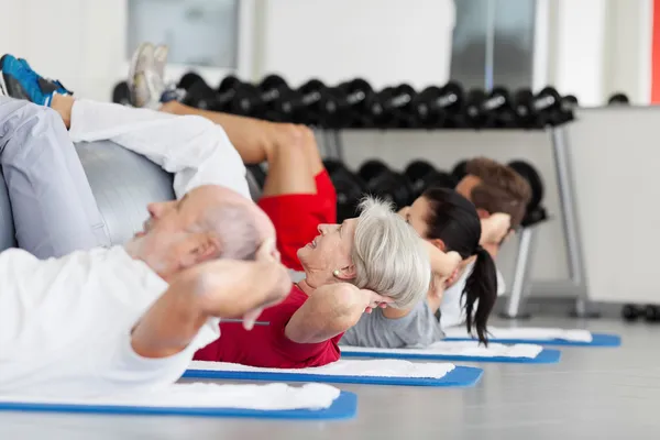 family with fitness ball practicing crunches in gym
