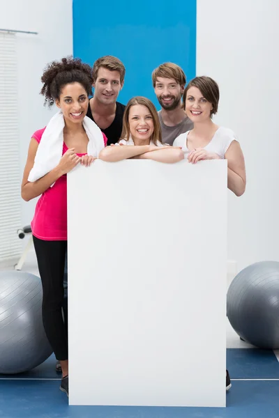 Happy fitness enthusiasts with a blank card