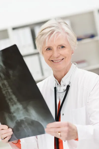 Smiling physician checking a pelvic x-ray