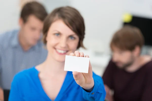 Friendly businesswoman holding up a blank card