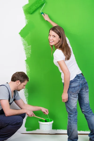 Young couple painting their new home green