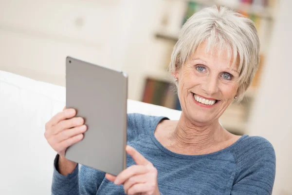 Happy senior woman holding a tablet