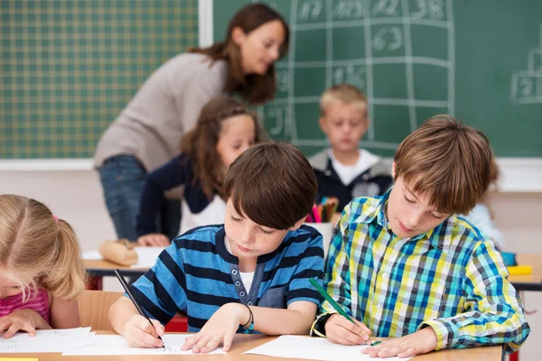 Children in class writing notes at school