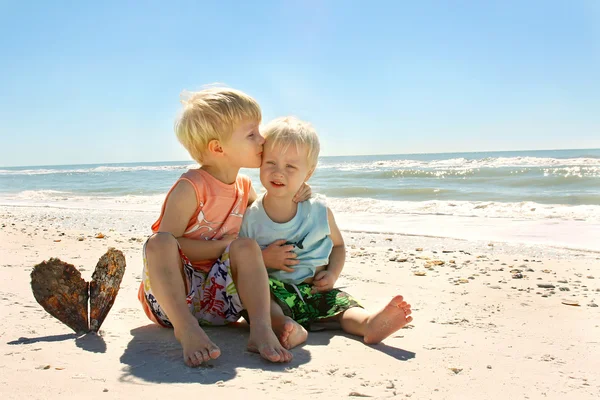 Big Brother Kissing Young Child on Beach