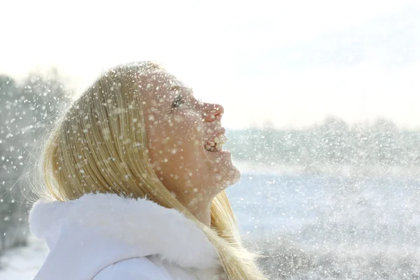 Happy Woman Enjoying Snow Falling Outside in Winter