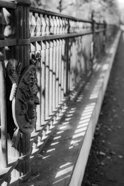 Iron fence with face in garden castle