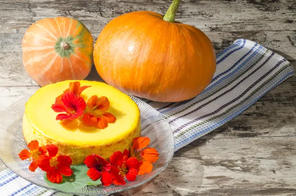 Cheesecake decorated with fresh flowers and pumpkin