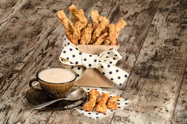 Garlic cheese bread sticks and cup of black tea with milk