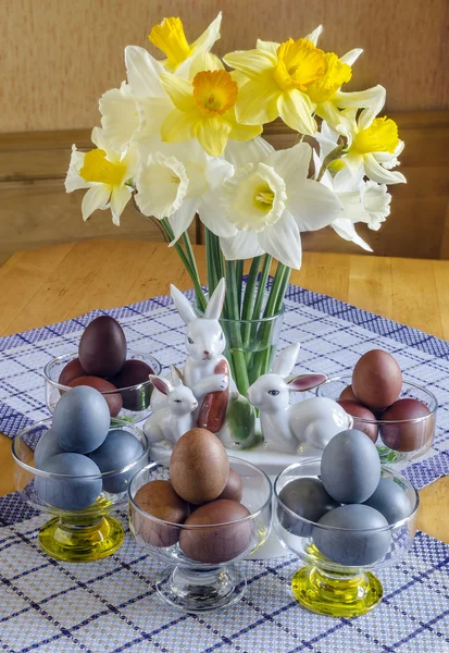 Festive Easter table decorated with flowers, colored eggs and cakes