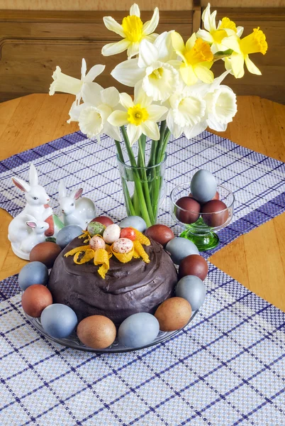 Festive Easter table decorated with flowers, colored eggs and cakes