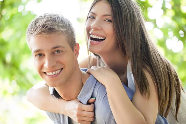 Portrait of a smiling young couple in an outdoor setting.