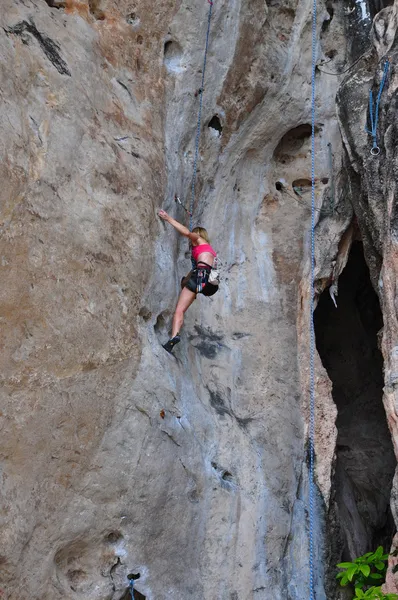 Woman climbing on the rock route summer