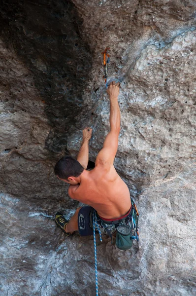 Man climbing on the rock route summer