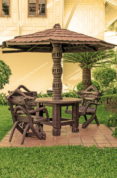 Garden furniture. chairs and table under wooden umbrella at gard